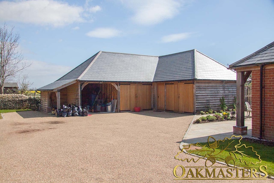 L shaped garage out building with open log store and two closed bays