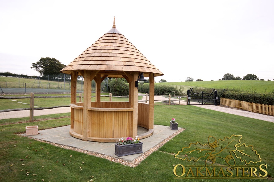 Circular oak gazebo shelter with partial timber clad walls and open aspect to surrounding views