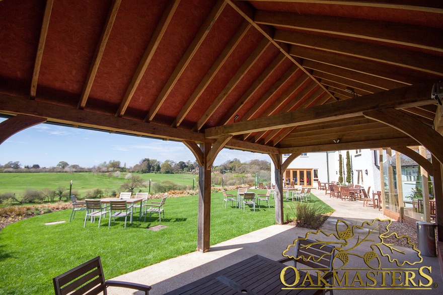 Underside of garden shelter roof with exposed oak beams and rafters