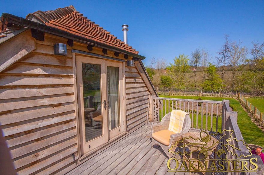 Sunny balcony off rooftop sitting room with oak framed patio doors on retirement house