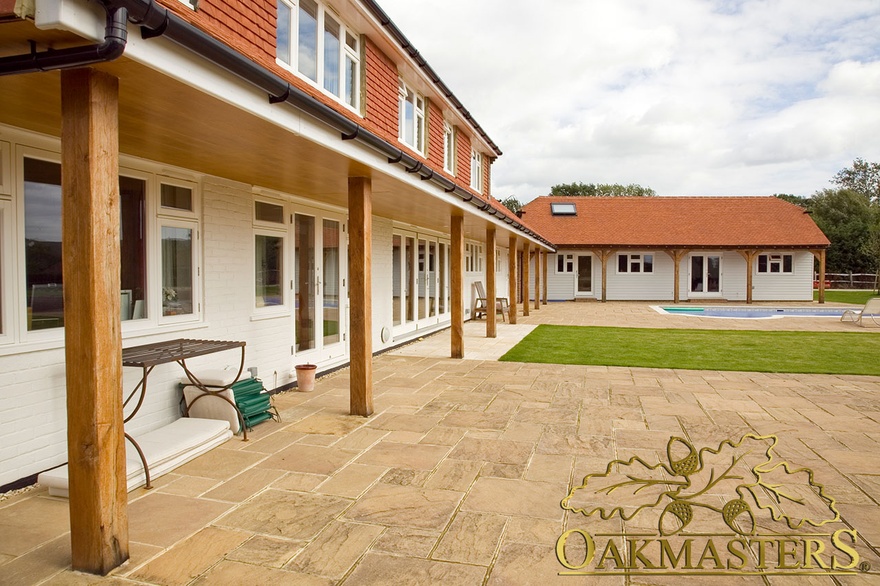 Oak framed country-house extension surrounding outdoor pool and patio