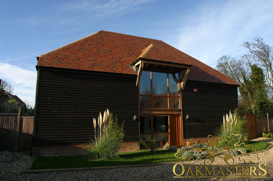 Two storey oak frame windows under projecting roof supported by oak braces on marketing suite 