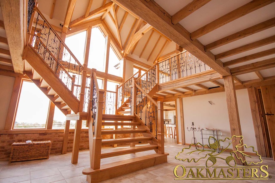 Open tread butterfly stairs in large hallway in front of glazed gable