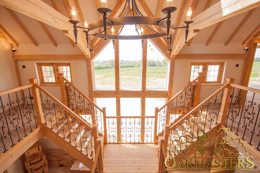 Oak and iron bannister and ballustrade framing glazed gable of country house