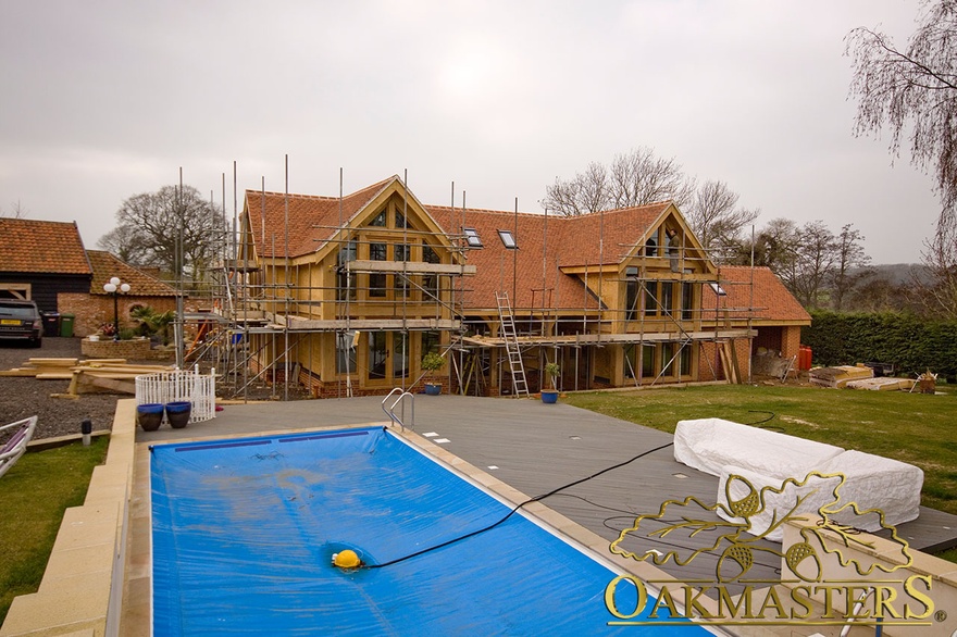 Large oakframe house extension with glazed gables awaiting completion