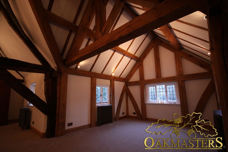 Spot lighting showcases exposed ceiling rafters in listed extension room