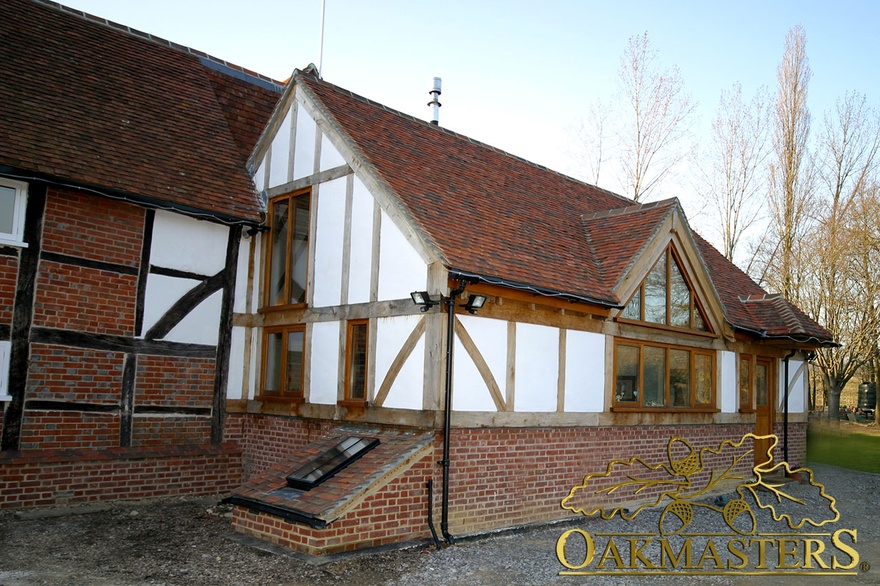 Brick and exposed oak timber frame with glazed gable on listed house