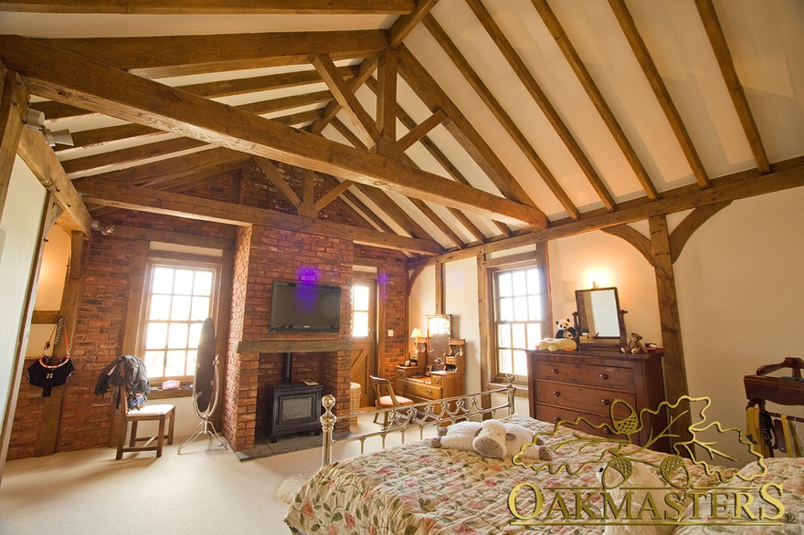 Exposed ceiling truss and rafters in Isle of Man Manx oak and stone house bedroom