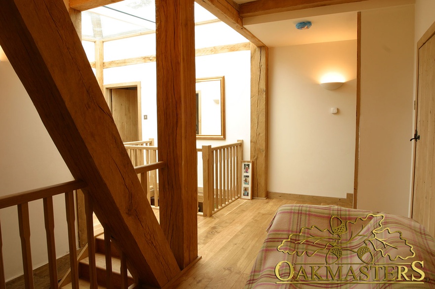 Oak columns surround skylight in upstairs hallway of country house extension