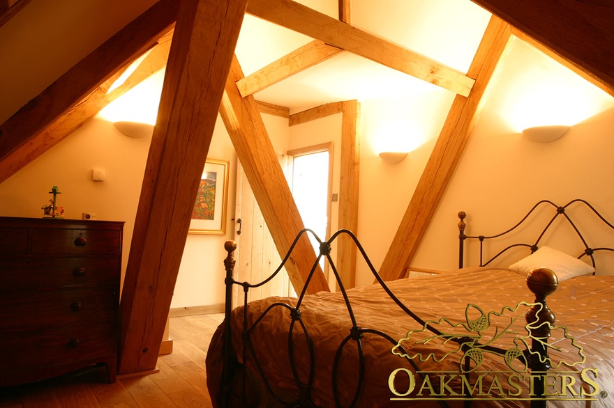 Bedroom nestled amongst oak ceiling posts in country house