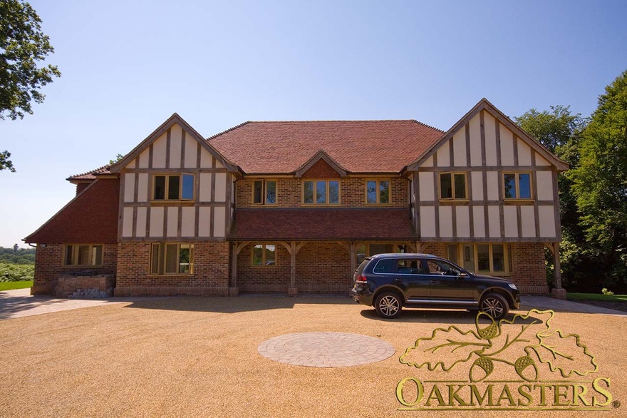 Porch with curved oak braces between tudor style oak cladding on modern home