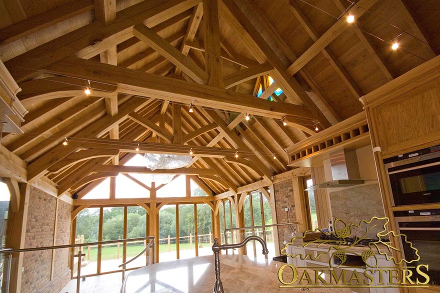 Large open plan family room and bespoke kitchen beneath vaulted oak ceiling