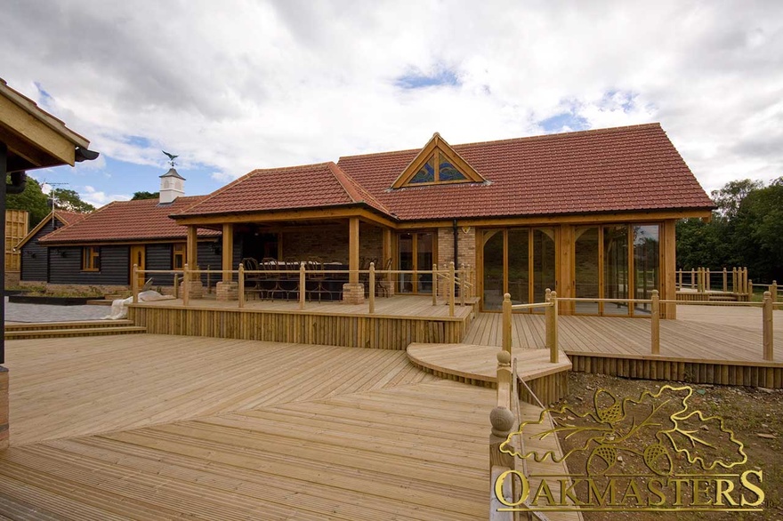 Extensive wood decking patio area with steps and fencing leading up to single storey residence