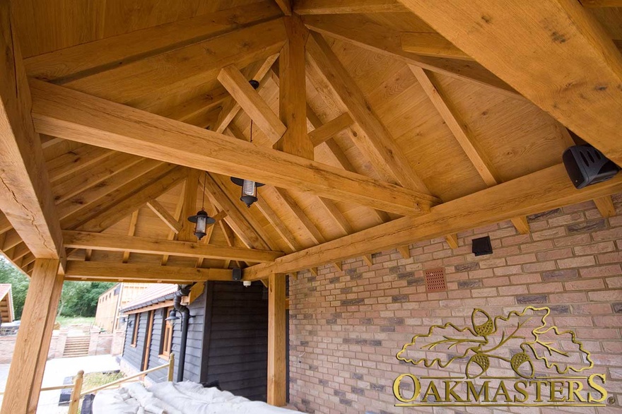Underside of oak framed veranda shelter with exposed oak trusses and rafters