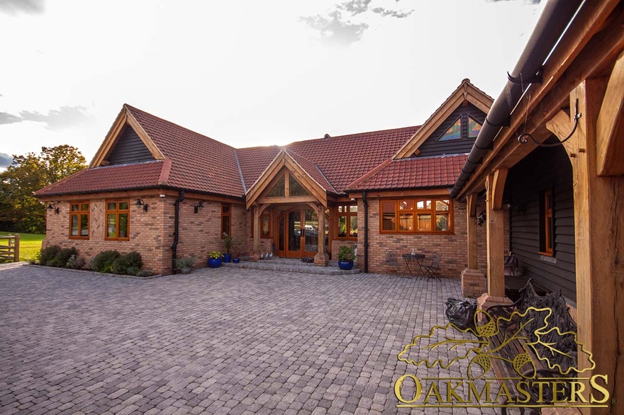 Front exterior of single storey country residence comprised of brick and exposed oak frame and oak cladding