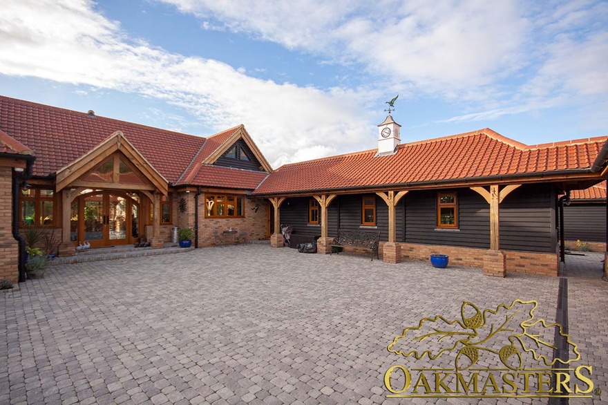 Front of single storey country residence with oak cladding and oak frame porch