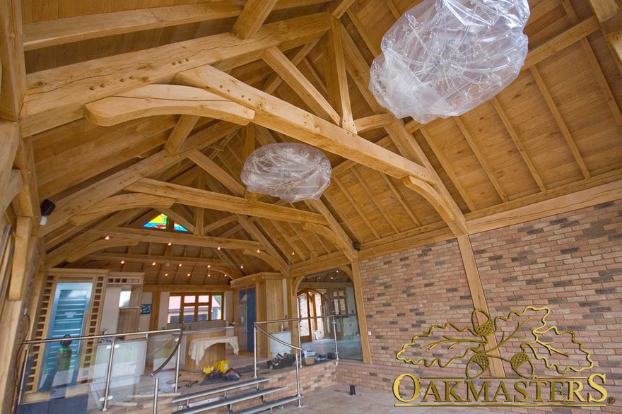 Open ceiling with exposed raised tie trusses in large kitchen living space in country residence