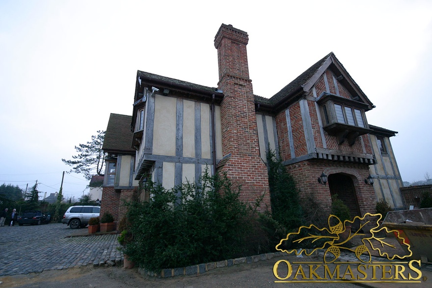 Brick chimney between tudor style oak cladding on new build