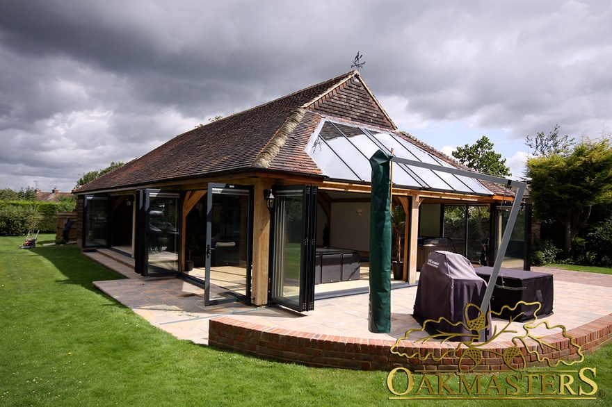 Oak framed pool building with triple aspect aluminium bifold doors