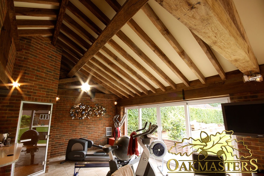 Oak rafters above gym area of oak and stone poolhouse 