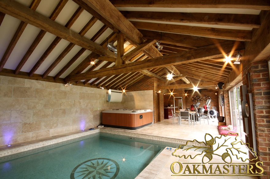 Vaulted roof with exposed rafters and truss in oak and stone pool house and gym building