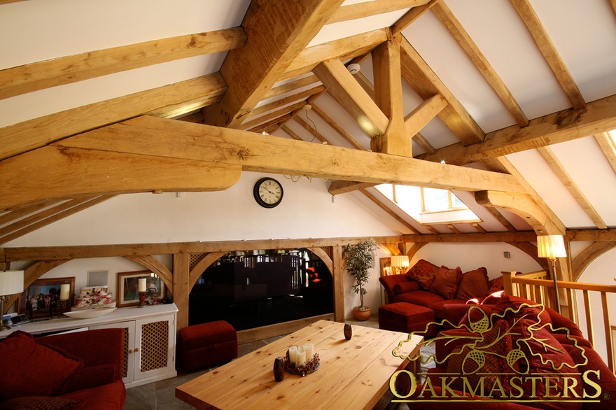 Cosy lounging area in poolhouse with raised oak tie truss and exposed rafters