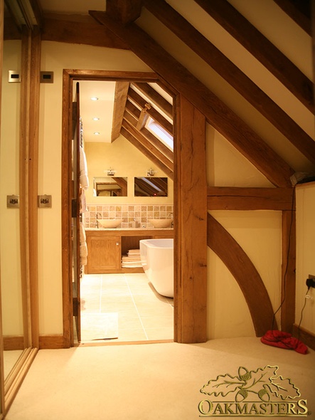 Queen post truss forms part of the doorway into this loft bathroom