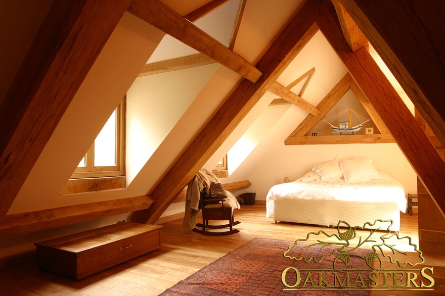 Attic bedroom with contemporary exposed oak roof trusses and oak purlins