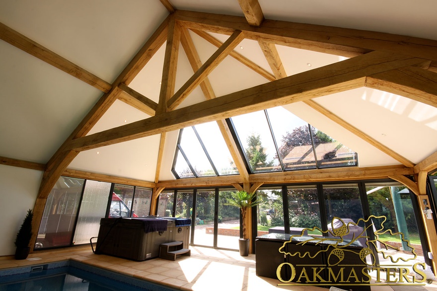 Vaulted ceiling with exposed truss above jacuzzi and pool