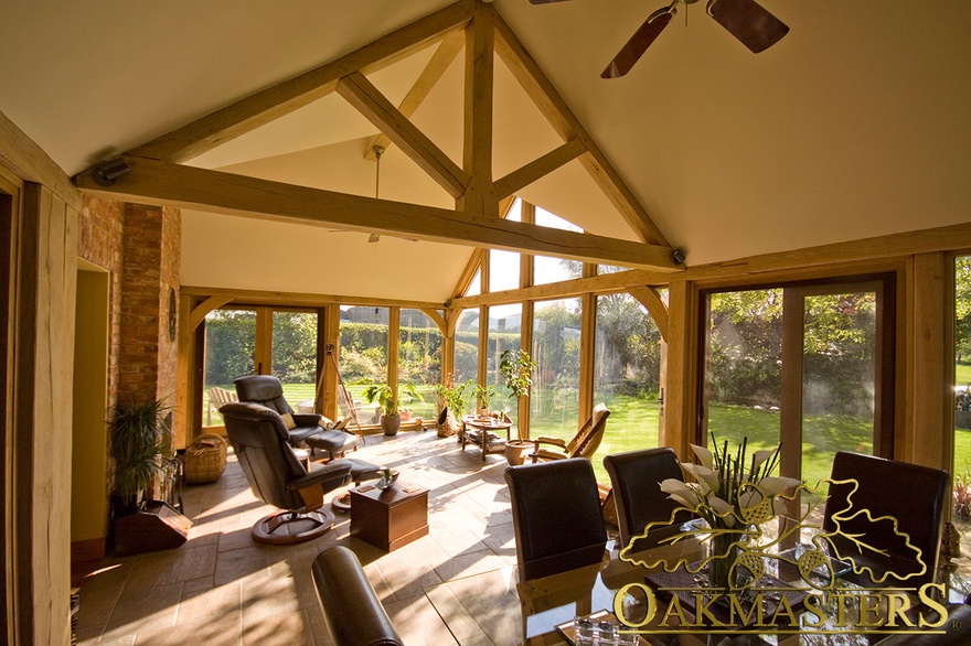 King post truss divides sitting and dining area in light filled sun room
