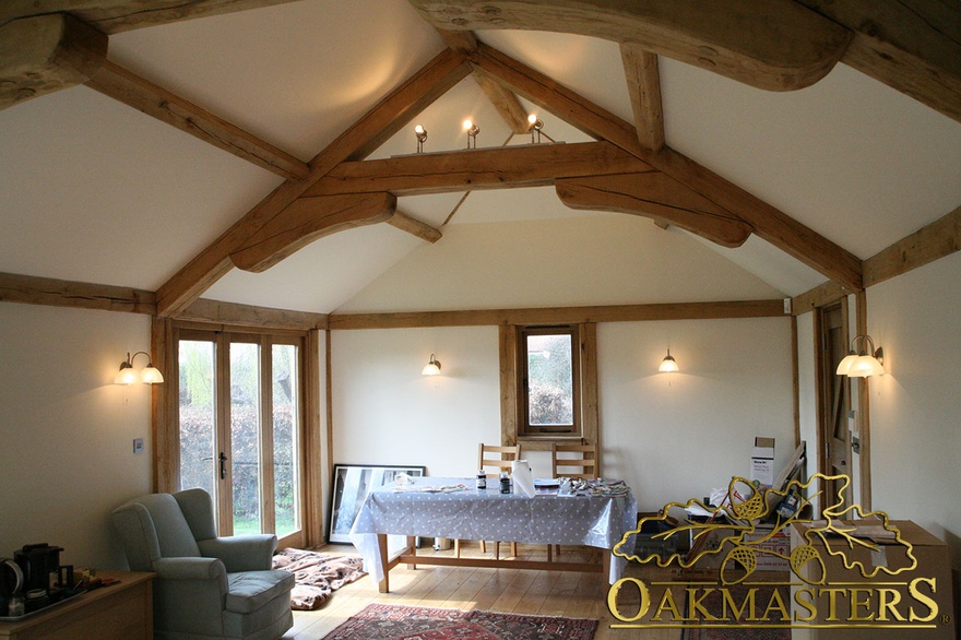 Raised tie truss and curved braces and oakframe patio doors in cosy garden room