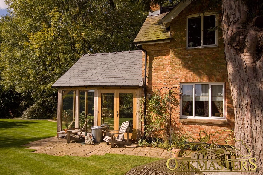 Sunny patio outside fully glazed garden-room built to match cottage