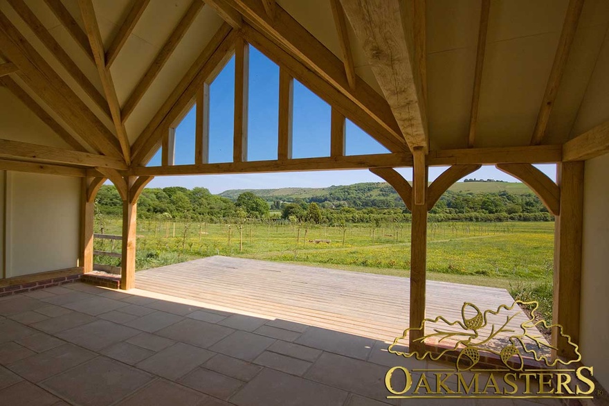 Rural view framed by glazed gable and open bays in amenity building