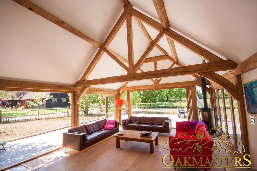 Sitting area in modern garden room opens out to garden with bi-fold glazed doors