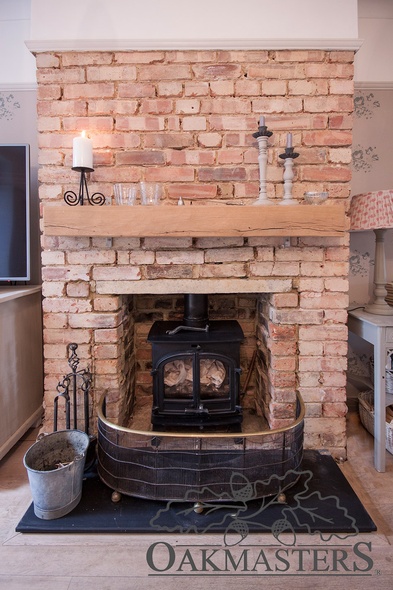 A simple straight oak beam mounted on the front of this brick fireplace creates a distinctive feature