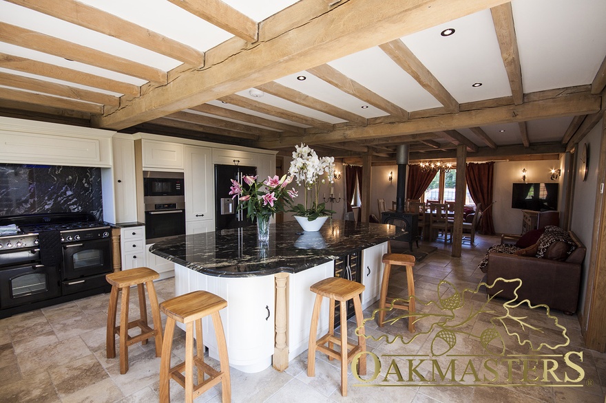 Large kitchen island with oak ceiling beams above
