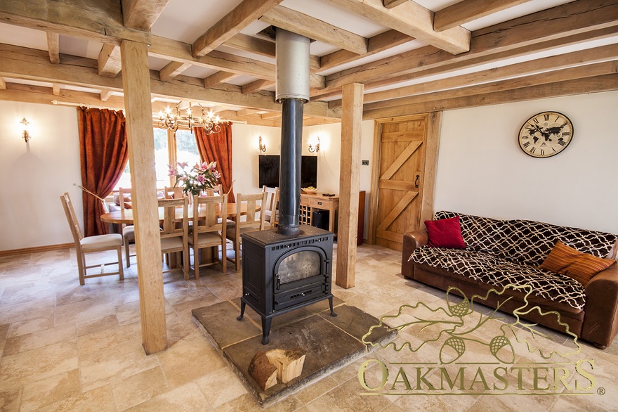 Unusual oak beam ceiling layout in a country manor allows for the wood burning stove flue to pass