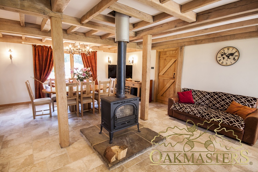 Inside, a cosy open plan kitchen diner with a wood burning stove