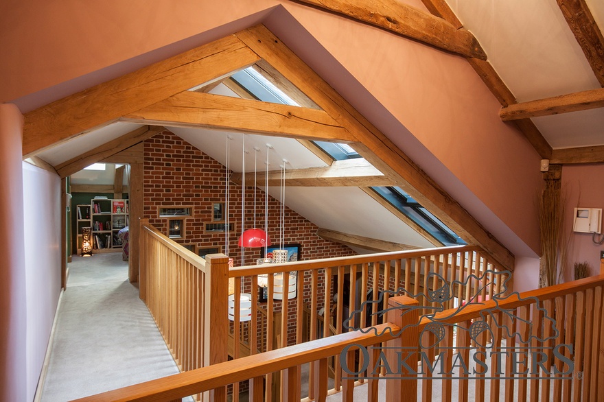 Floating landing with exposed oak trusses overlooks the entrance hall