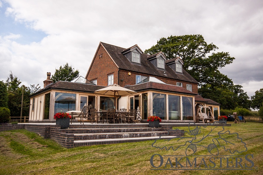 B rick patio fills the gap between the two oak extensions