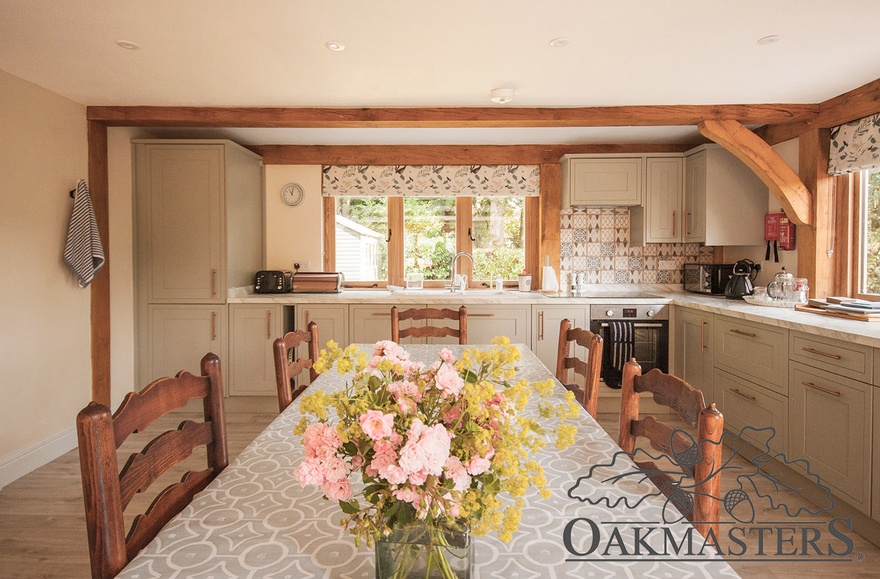 Large open plan kitchen is full of natural light streaming in through the oak windows on two sides.
