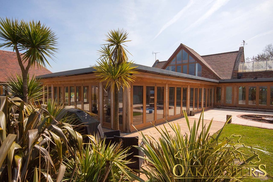 Outside, the oak framed swimming pool house  is surrounded with a stone patio and plants