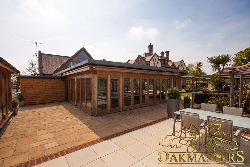 On the outside, the flat roof of the oak pool building creates a low profile