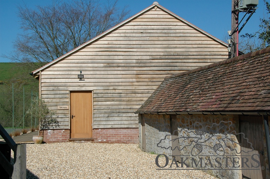 Outside of the pool building is clad with oak featheredge cladding