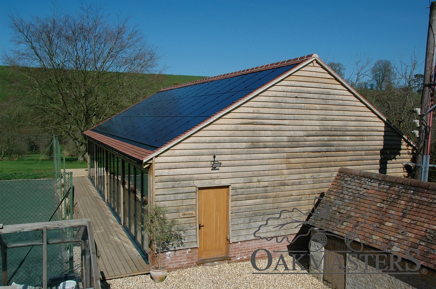 Weathered oak cladding makes the new pool building blend beautifully with existing older buildings