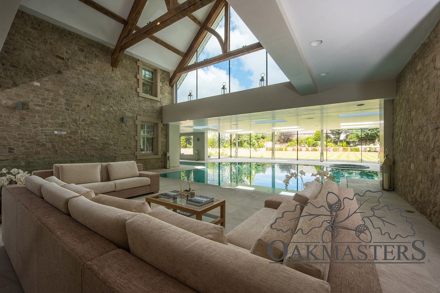 Lounging area overlooking to pool also has a view of glazed oak truss