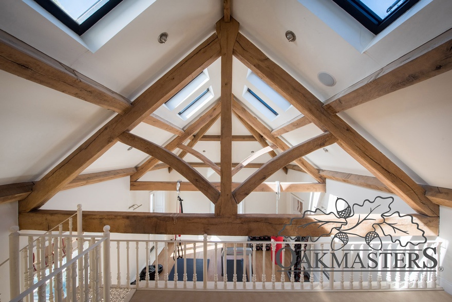 View through a set of oak king post trusses above a gym