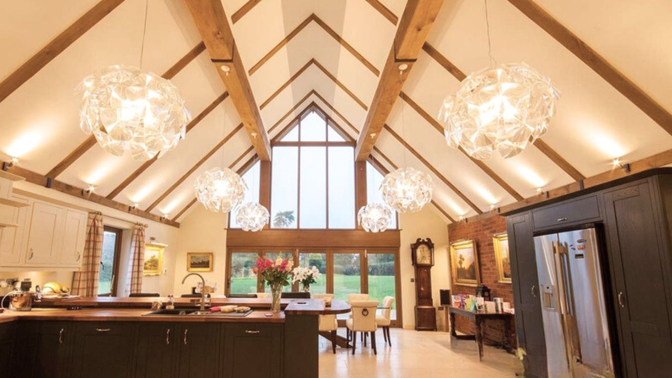 Spacious kitchen featuring exposed three-sided oak beam covers across the ceiling, concealing RSJs for a seamless and stylish look.