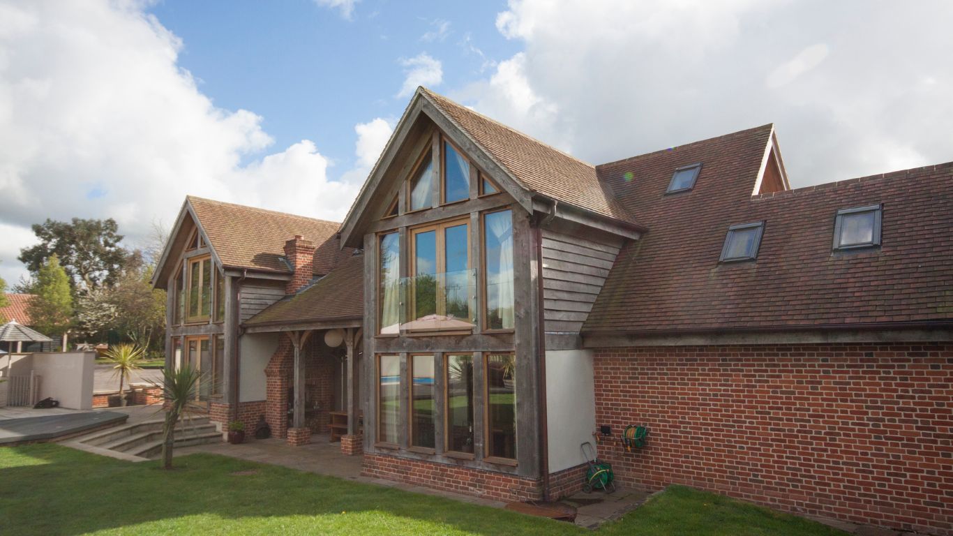 Exterior view of a building featuring mock Tudor oak wall cladding, adding a rustic charm to the facade. The rich texture of the oak cladding enhances the architectural appeal of the structure.